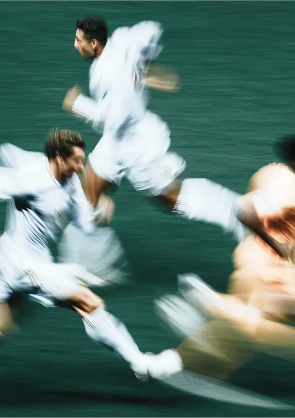 Aerial view of a stadium during a soccer match, with the field lit and crowd visible.